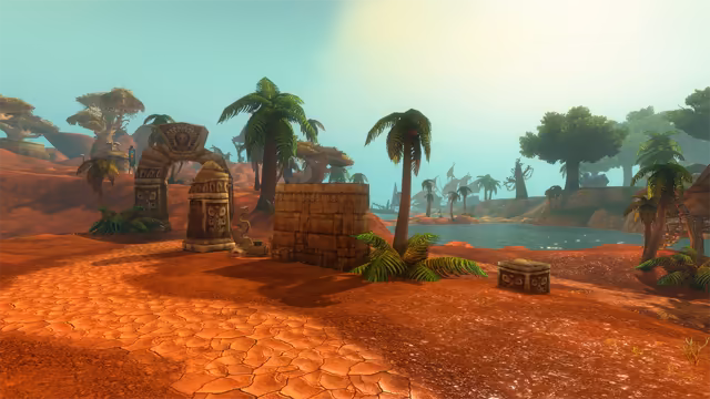 Cracked red earth stretches toward a broken stone archway topped with a carved face, a square block of stone wall and a small carved stone chest among palms and ferns. Beyond, a calm lagoon leads to a grassy shore with large trees and a blue-roofed building, while sailing masts and flat-topped trees fade into the pale green sky.