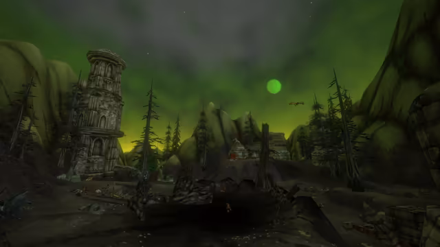 At night beneath a glowing green sky and a round green moon, a tall ruined tower of carved gray stone stands among bare, spiky pines and broken columns. The dark ground in front is torn and littered with debris, small red horned figures stand about, and a winged creature flies over a hill with ruined stone buildings.