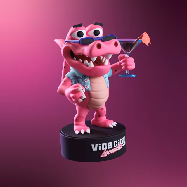 A glossy pink cartoon alligator figure with big eyes, purple sunglasses resting on its snout and a toothy grin wears an open light blue palm-print shirt, raises a martini glass with a paper umbrella in one hand, holds a hand-rolled cigarette in the other, and stands on a round black base printed Vice City Leonida, against a magenta backdrop.
