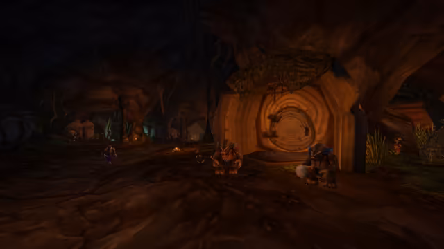 In a dark earthen cave, a wooden doorway with a round door patterned like tree rings glows warm orange behind two brown, bear-like furbolgs wearing blue feathers, one carrying a stick and the other a white-headed club. Further back, a purple-skinned figure with antlers walks near a small campfire, and a smaller figure stands among the rocks.