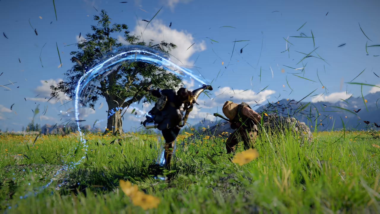 In a sunny meadow of tall grass and yellow flowers beside a lone tree, a fighter in dark armor spins in a high kick, trailing a wide curved streak of glowing blue light. The kick catches another man, who doubles over at right. Blades of grass and leaves fly through the air.