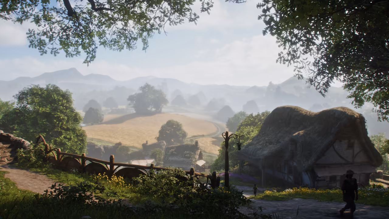 Hazy morning seen from under leafy branches. A lane with a rustic wooden fence and an iron lamp post curves past a cottage with a heavy thatched roof at right, where a figure in a brimmed hat walks. Below, a patchwork of golden fields, a winding road, rounded green trees and stone cottages stretches to a range of blue mountains. No game interface is shown.