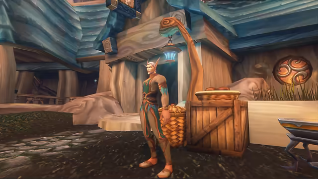 A man with pale peach skin, swept-back silver hair, a short white beard and long pointed ears stands on a cobbled street in a fitted green and tan outfit with copper trim. Behind him a doorway glows blue beneath a curled wooden lamp post with a hanging lantern, beside a woven basket and a wooden crate holding a basket of bread, under heavy wooden buildings with blue roofs and a round copper emblem on the wall.