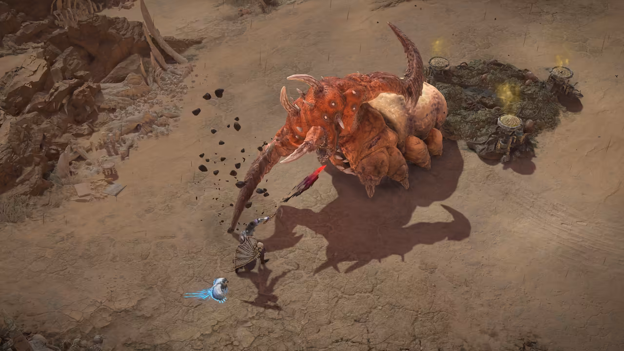 Top-down view of sandy ground. A giant segmented orange creature with horns and sickle limbs rears over a small armored figure; a white bird with blue light flies at lower left.
