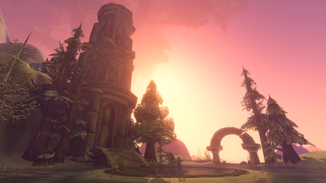 Seen from low down, a weathered, ornately carved stone tower rises at left beside tall conifers, and a broken stone arch stands at right, against a hazy pink and gold sky with the faint outline of vast leafy branches overhead. In the center a lone robed figure stands in a shallow circular pool edged with carved stone.