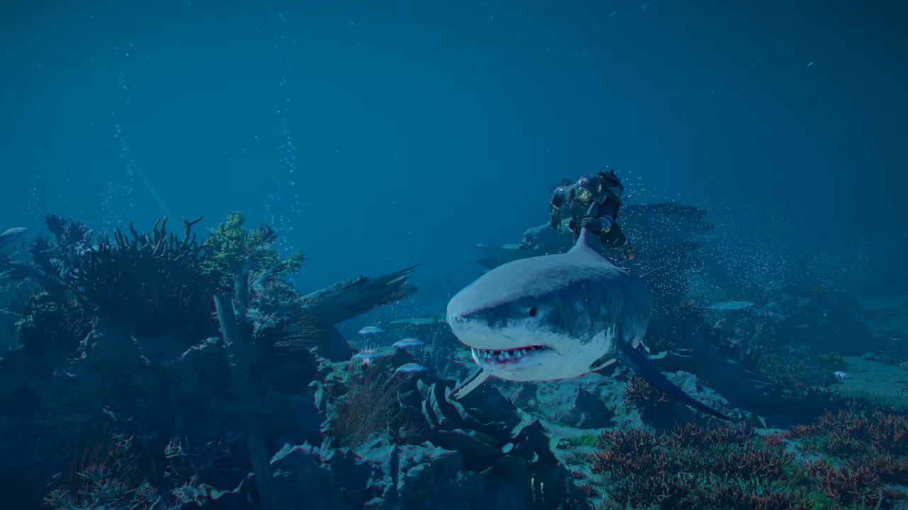 Underwater in blue light, a large great white shark swims toward the viewer with its mouth slightly open, its teeth showing. Above and behind it a diver in a heavy suit with a round metal helmet swims along. Coral, sea plants and small fish cover the reef below.
