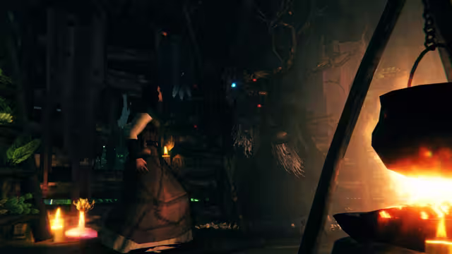 Inside a dim wooden hut, a woman in a long dark dress stands among candles and potion bottles beside a black cauldron over a fire; a dark antlered figure hangs behind her.