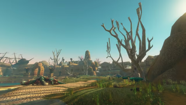 Under a clear teal sky, tiers of carved sandstone ruins with arches, statues on plinths and a pointed tower stretch across the view, behind a cobbled path where a large green scaled creature lies slumped. Leafless pale trees stand in the grass at right, and the hull and broken masts of a ship sit on the ruins at far left.