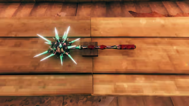 A one-handed mace with a red-wrapped handle and a dark head bristling with long glowing green spikes rests on wooden planks