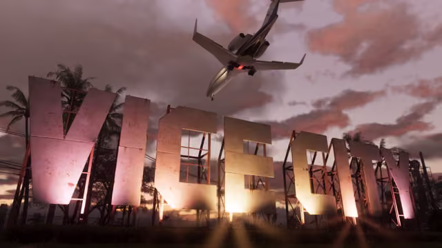 Huge weathered block letters spelling Vice City stand on metal scaffolding among palm trees, glowing pink and orange from floodlights, as a private jet passes overhead through a cloudy evening sky.