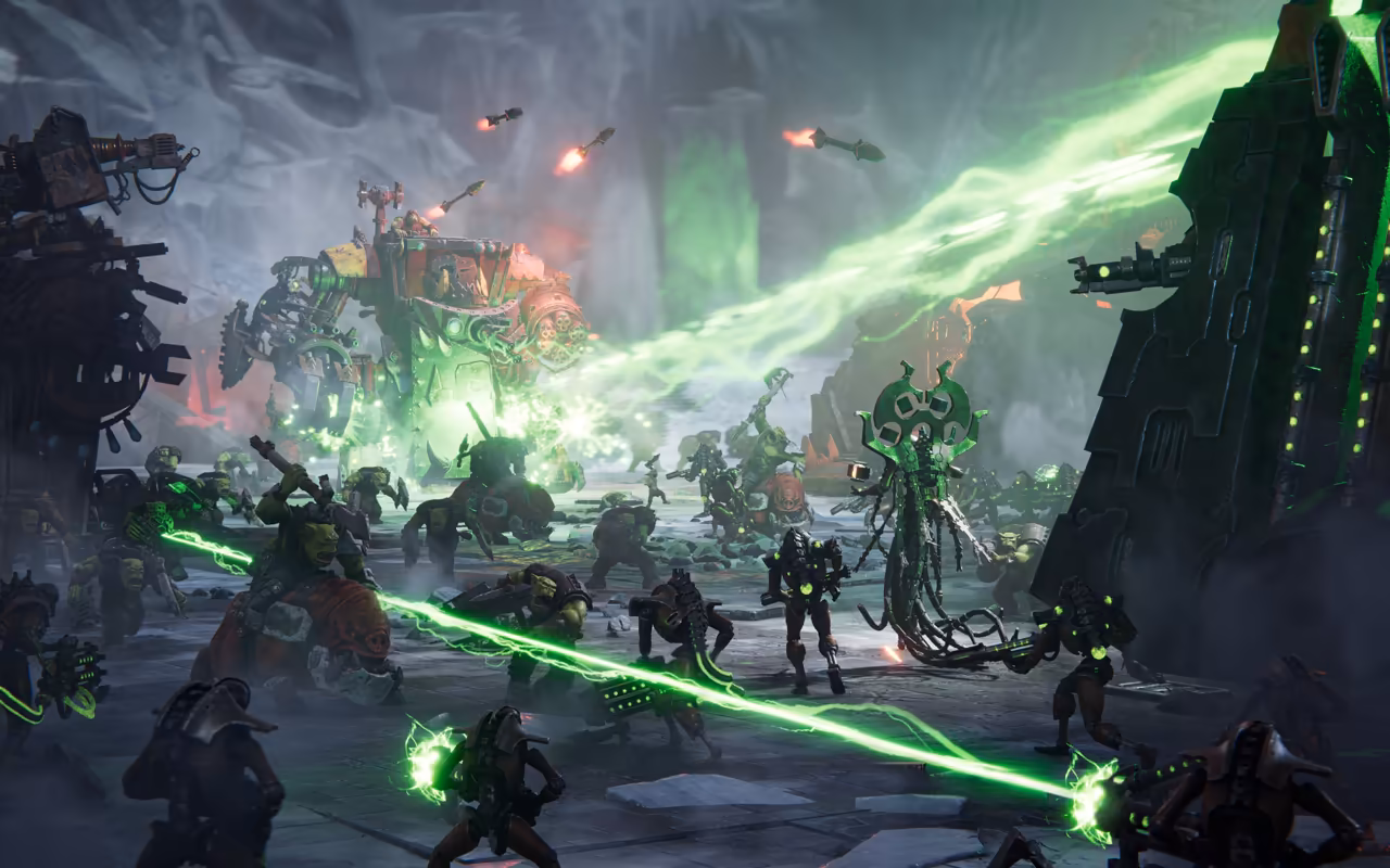 Bright green rays cross a smoky dark scene; skeletal robots and a spidery leader in the middle and Ork walkers far off.