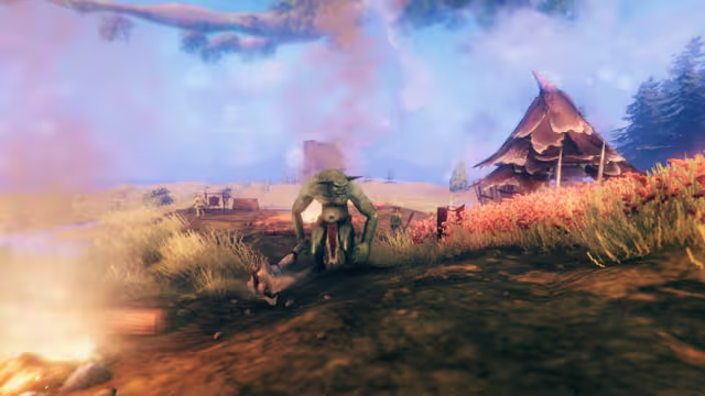 A large, muscular green goblin holding a heavy club stands on grassy ground in front of a hut with a pointed roof, red-flowered grass at right and a campfire at lower left.