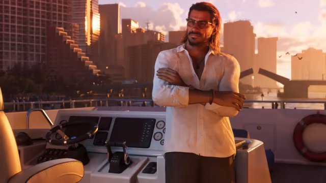 A man with long swept-back hair, a beard and tinted glasses stands with folded arms in a white shirt at the helm of a boat, a lifebuoy beside him, with city towers and an open drawbridge glowing in the evening sun.