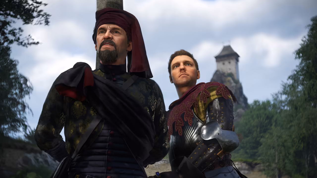 Low view of a bearded man in a red turban hat and black coat beside a young man in a red patterned shoulder cape and plate armor, both gazing upward; a stone tower on a rock stands against the sky behind them.