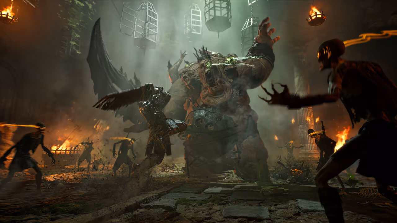 A smoky stone hall lit by fire. Iron cages hang from the ceiling. At center a huge, swollen monster with several snarling heads, glowing green eyes and a round shield-like plate strapped to its belly towers over a fighter in black armor who leaps at it with a large wing-shaped blade. Thin dark figures with burning yellow eyes run in from both sides, one reaching forward with clawed hands at right. Fires burn along the walls. No game interface is shown.