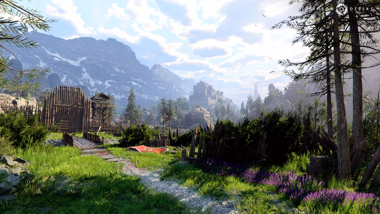 A bright green valley with a gravel path through grass and patches of purple flowers. A tall wooden palisade with a gate and watchtower stands at left, a red cloth lies on the grass, tall pines stand at right, and a stone castle sits on a rise below gray mountains with snow.