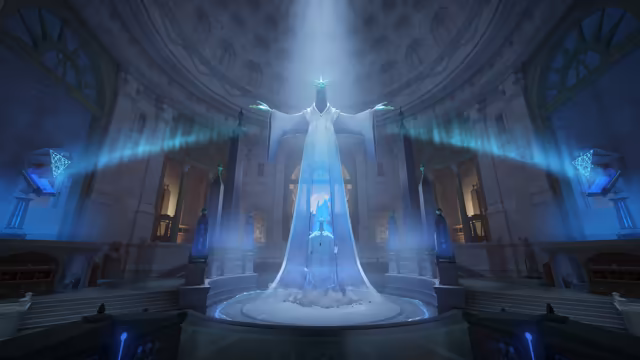 A circular hall with a coffered dome and arched windows, bathed in blue light; at its center a giant white robed figure spreads its arms above a glowing crystal on a round base, with blue banners of light streaming to the sides.