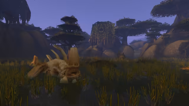 The bleached skull of a big horned animal lies half sunk among golden reeds in dark marsh water, with a crocodile-like creature low in the water behind it. Trees with flat, layered canopies, one draped in hanging moss, rise over smooth gray boulders under a pale violet sky.