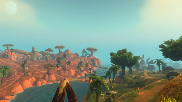 From a grassy rise behind a pair of crossed wooden poles, the view runs over a blue inlet to rolling red rock hills dotted with palms, flat-topped trees, a pale stone tower and a thatched lookout on stilts, linked to the shore by a long wooden bridge. On the right, broad trees, small torches and a blue-roofed hut stand on a green shore, with sailing ships in the haze and a pale sun in the corner of the sky.