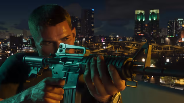 Close-up of a man sighting down a teal-lit assault rifle over a ledge, with a skyline of lit towers, highways and two green-topped buildings behind him in the dark.