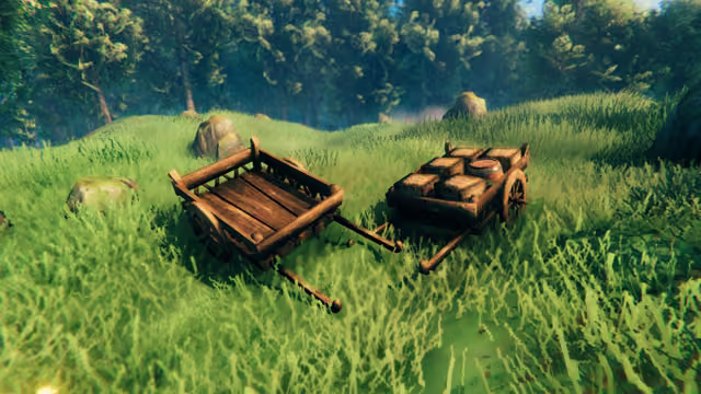 Two wooden two-wheeled handcarts stand in tall green grass at the edge of a forest; the left one is empty and the right one carries wooden crates and a barrel.