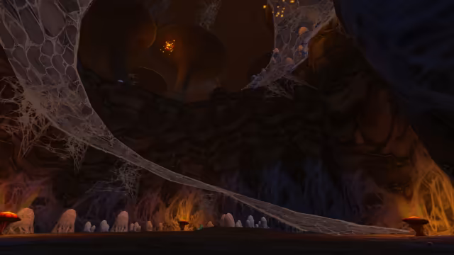 A huge curtain of gray web sweeps diagonally across a dark rock wall, and more webbing climbs to a ledge dotted with small pale shapes. Rows of pale, rounded mounds line the foot of the wall between glowing red mushrooms, with giant mushroom shapes and a glowing orange pod high above.