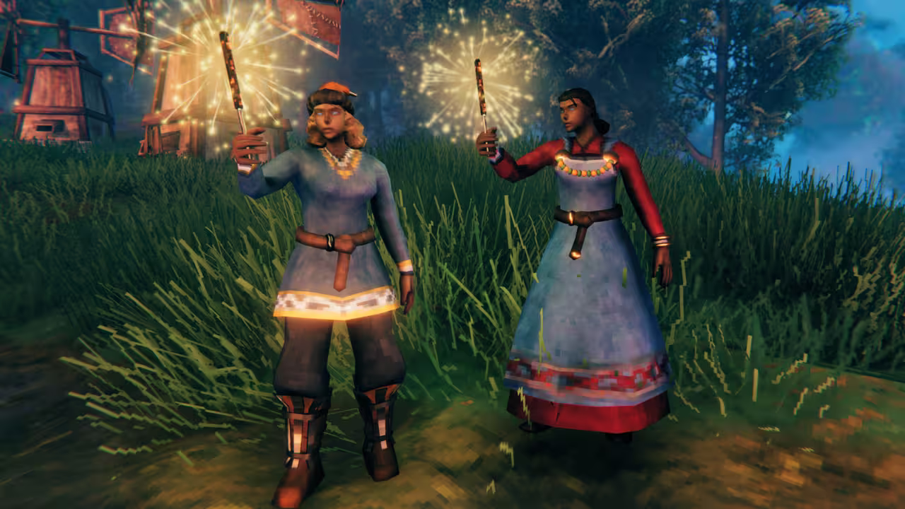 Screenshot of two Vikings holding lit sparklers at dusk, one in a blue tunic, dark trousers and a small orange cap, the other in a blue and red embroidered dress, with a windmill behind them