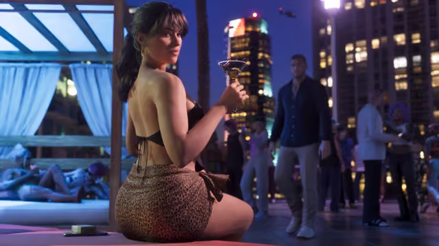 At night, a woman in a black top and a leopard-print skirt sits on a cabana bed holding a martini glass and looks over her shoulder, while behind her a man in a dark shirt walks among partygoers on a rooftop surrounded by lit skyscrapers.