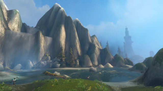 Huge gray cliffs streaked with moss and misty falling water tower over a shallow pool with fallen logs and boulders under a blue sky. A long-legged bird with blue and white feathers stands on the grassy bank at the lower left, a smaller brown bird walks nearby, and a pale tower and dome stand in the haze on the right.