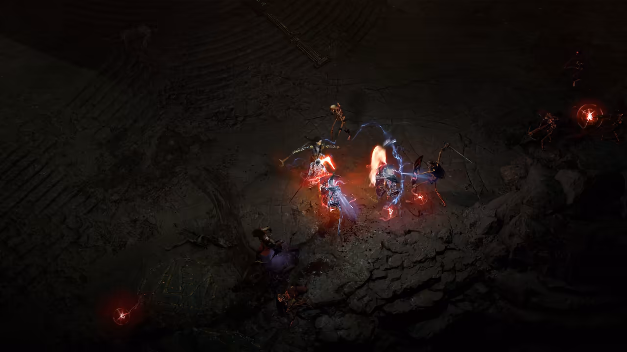 A mostly dark cavern seen from above. In the center several characters cluster, flashes of blue lightning and red light around them, pale skeletons nearby and two glowing red spheres on the ground.