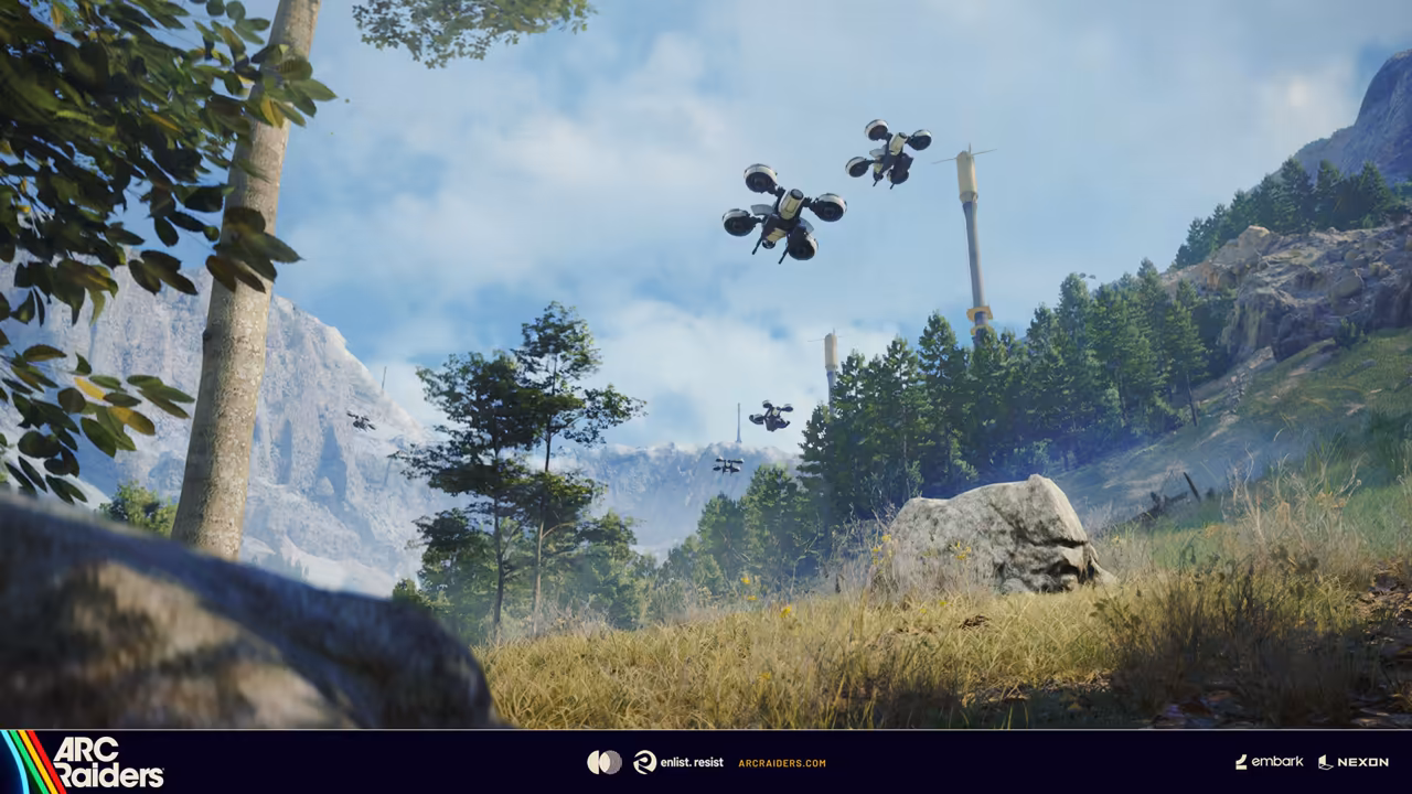 A sunny hillside with long grass, a pale rock and a line of trees; dark four-rotor drones in the air.