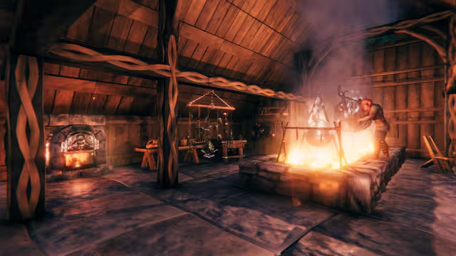 The interior of a timber longhouse: a Viking tends a cauldron hanging over a raised stone hearth, smoke rising to the rafters, with a stone oven, a table and hanging decorations along the far wall.