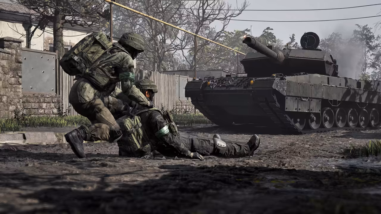 A crouching soldier with a backpack pulls a soldier lying on his back by the vest along a dirt road; a dark battle tank sits behind them beside a wooden fence and bare trees.