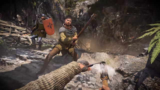 First-person view of an arm in a quilted sleeve holding a flaming torch toward a shouting man with a long club on rocky ground; behind him a helmeted man with a red heraldic shield and a spear.