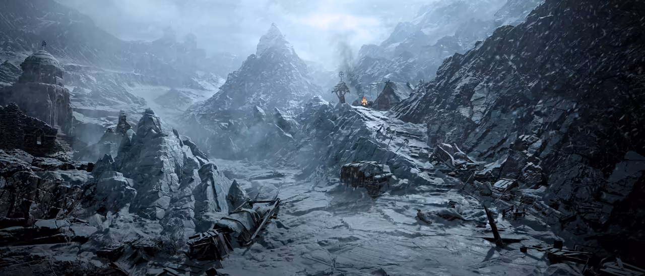 A cold blue-gray mountain scene with falling snow. A domed stone building sits on the left ridge, jagged rocks and a sharp peak rise in the middle, and broken carts and debris lie half buried in the snow of the valley floor.