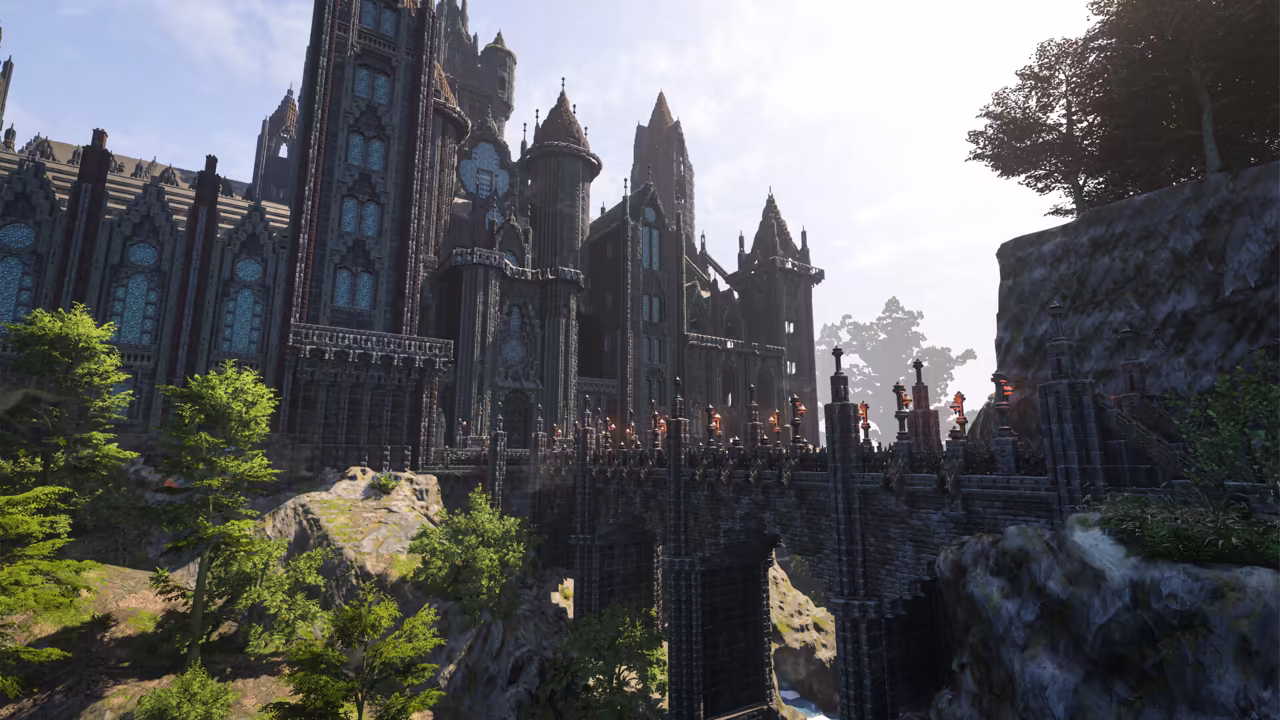 Low view up at an enormous dark gray castle with pointed spires, round turrets and tall arched windows of blue stained glass. A long stone bridge lined with railings, small towers and red lanterns spans a gorge from the castle to a mossy cliff at right, supported by tall arches. Green trees grow on the rocks below. No game interface is shown.