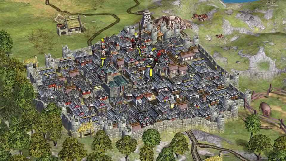 3D view of a big square city packed with gray roofed houses inside crenellated walls with towers, figures in armor among the roofs, a road leading in and a pig in a field at right.